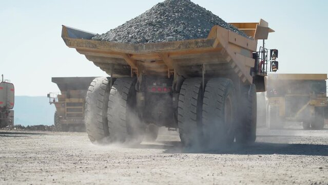 Large quarry dump truck transporting ore on open pit mine, slow motion