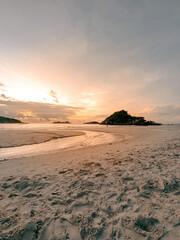 Fototapeta na wymiar Sunrise reflections on the beach sand. Textured and watery sandy beach.