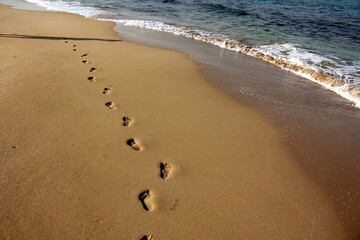Fototapeta na wymiar Footprints in the sand on the mediterranean sea