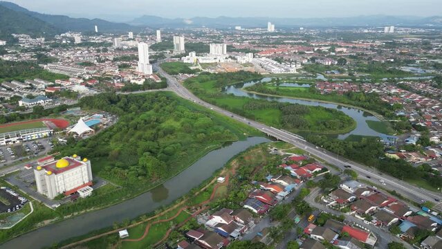An aerial view of a residential area with a Sungai Juru river running through it