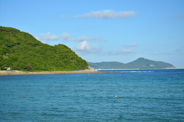 green mountain and blue sea under blue sky in sunny afternoon day