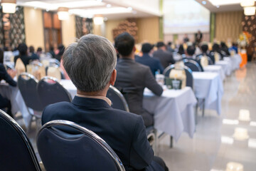 Fototapeta premium Rear view of businessperson participating in a business seminar in the hall