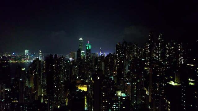 Vol au dessus de la ville de Hong Kong, China, Asie  au milieu des b&acirc;timents et gratte-ciel et au-dessus des tours immenses et de rues illumin&eacute;es pendant la nuit.