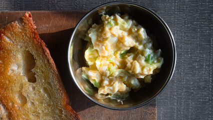 Homemade egg mayo with bread on a cutting board