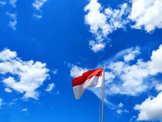 Red and white flags fluttering in the wind under the blue sky