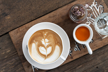 Cup of coffee with beautiful Latte art on wooden table background