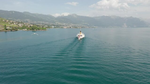 Drone flying away from classic cruise ship on Lake Geneva on a summer day