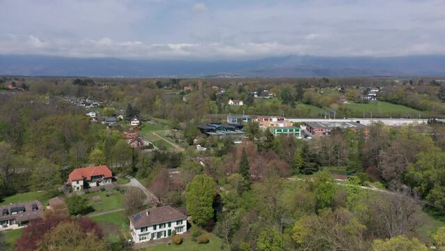 Drone flying away from FIBA headquarters and revealing multiple expensive houses in a rustic town