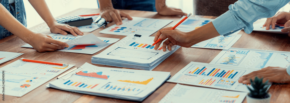 Poster Analyst team utilizing BI Fintech to analyze and pointing at financial dashboard paper office. Businesspeople examining report paper on table for business insight. Panorama shot. Scrutinize