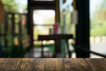 Empty dark wooden table in front of abstract blurred boken bankground of restaurant. Can used for display or montage your products. Mock up for space.