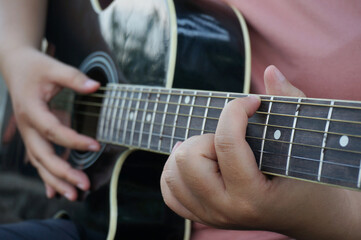 Fototapeta na wymiar Young woman playing guitar at home.