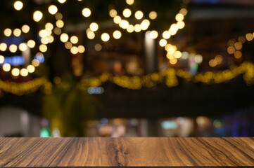 Empty dark wooden table in front of abstract blurred boken bankground of restaurant.