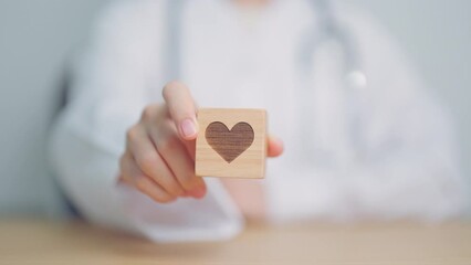 Doctor hand holding heart shape block in hospital. love, donor, world heart day, world health day, CSR donation and Insurance concepts
