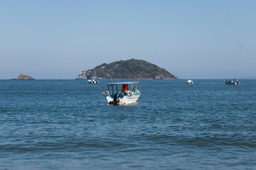 Rustic boat on the sea coast with island in the background