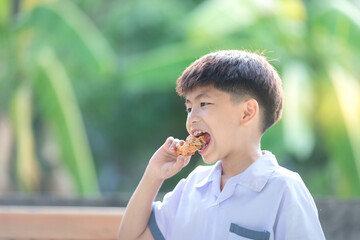 Fototapeta premium little boy eating fried chicken very delicious face.