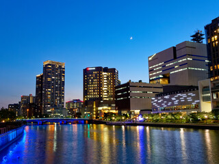 Fototapeta na wymiar 夕暮れの大阪 ほたるまちのビル群とライトアップされた堂島川周辺
