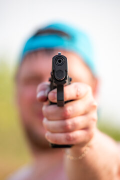 A gun in the hands of a man close-up in nature.