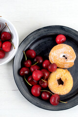Dish with delicious doughnuts and cherries