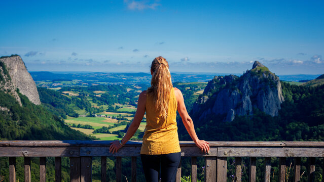 Woman ooking at beautiful Auvergne landscape panorama in France ( Sanadoire and Tuiliere rocks) Auvergne volcano, Monts Dore mountain