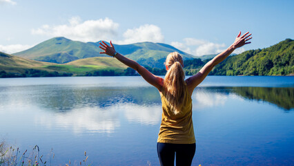 Happy woman in front of beautiful lake ( Guery Lake in Auvergne, France)