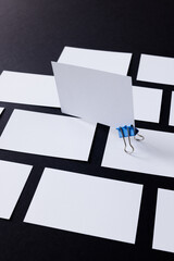 White business cards with paperclip and copy space on black background