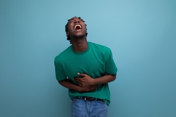 positive american young man with dreadlocks in casual green t-shirt on background with copy space