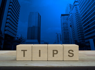 TIPS letter on wood block cubes on wooden table over modern office city tower and skyscraper, Business customer service and support concept