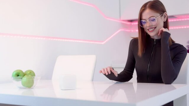 Gamer girl works and plays at the computer. Female in modern headphones interacting with network while having virtual reality experience. Augmented reality game, future technology, AI concept. VR. 