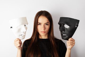 young woman holding a black and white theatrical mask in her hands, choice between truth and lies,...