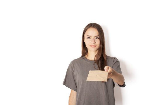 young woman postman with a letter on a white background, postal courier with documents in an envelope, a teenager delivers letters