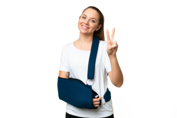 Young blonde woman with broken arm and wearing a sling over isolated chroma key background smiling and showing victory sign