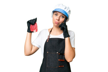 Butcher woman wearing an apron and serving fresh cut meat over isolated chroma key background thinking an idea
