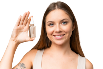 Young blonde woman over isolated chroma key background holding a serum while smiling. Close up portrait