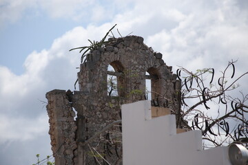 Campanario colonial de iglesia en ruinas, fondo de cielo azul y con nubes, 