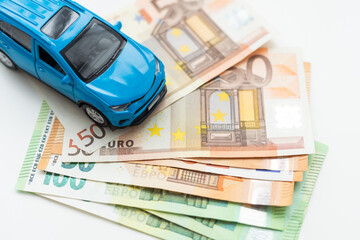 Car and money concept - toy automobile with euro money.
