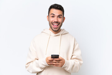 Young caucasian man isolated on white background surprised and sending a message