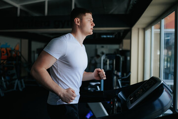Fototapeta na wymiar A male sportsman sweating profusely while doing cardio and other physical exercises at the training gym. Fit and Focused The Power of Cardio and Gym Training for Men