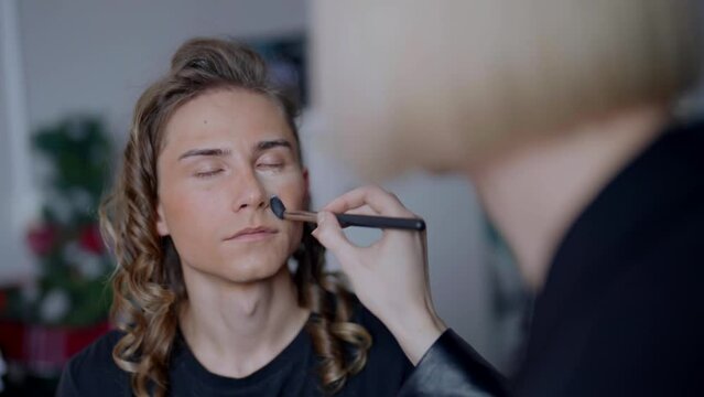 gay makeup artist and male model in backstage of travesty show, beauty and homosexuality