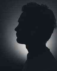 Silhouette of a man in distress in a dark room
