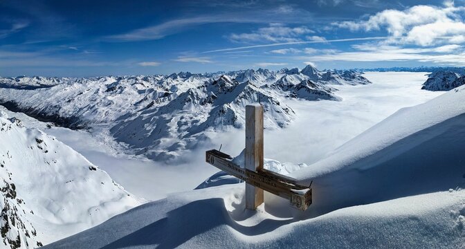 Summit cross on the Fluela Schwarzhorn above Davos. Fantastic view with sea of ​​fog. Ski mountaineering. Ski tour. High quality photo