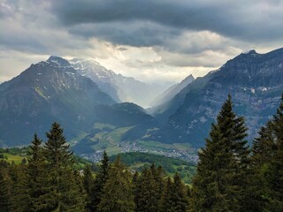 Fototapeta premium Farm near the Fronalp above Mollis Glarus. Dramatic evening mood. Wanderlust in the Swiss mountains.View of the Klöntal. High quality photo