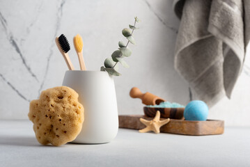 Eco-friendly bathroom accessories: bamboo toothbrush and natural sea sponge