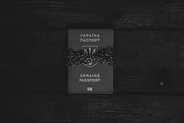 A foreign biometric passport of Ukraine tied with chains lies on a board an arrest and a ban of...