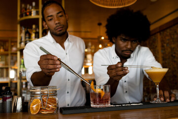two latin bartenders ending two cocktails