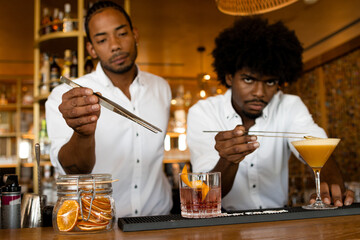 two latin bartenders with curly hair doing cocktails