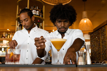 two lating bartenders working in the bar together