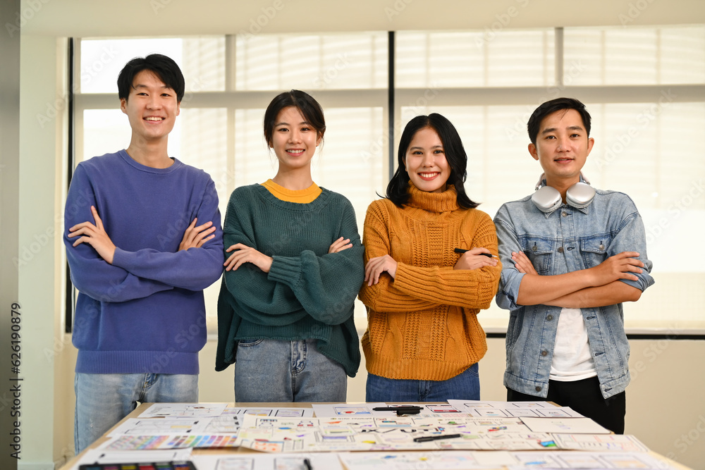 Poster group of developers standing with arms crossed and smiling to camera at creative office