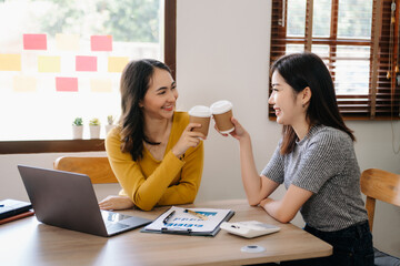 Two business worker standing and holding a coffee cup in modern office, successful, celebration, new project, team office concept in morning .