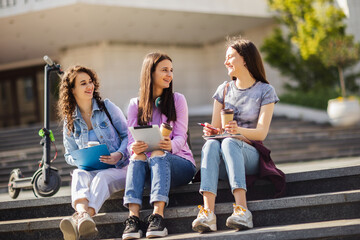 Group of collage girls sitting on bench and studying for school