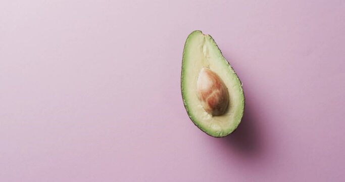 Video of sliced avocado with copy space over pink background